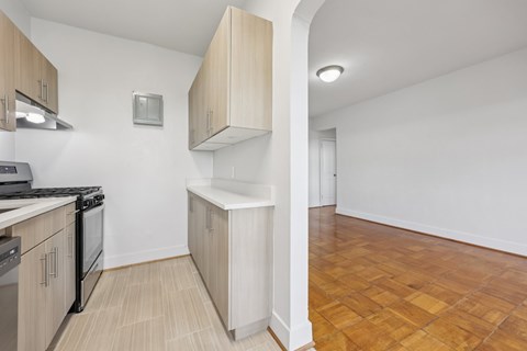 A kitchen with wooden cabinets and a tiled floor.