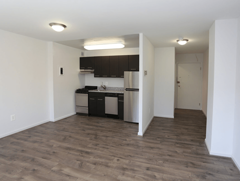 A kitchen with white walls and wooden floors.