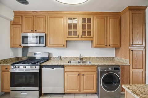 A kitchen with wooden cabinets and granite countertops.