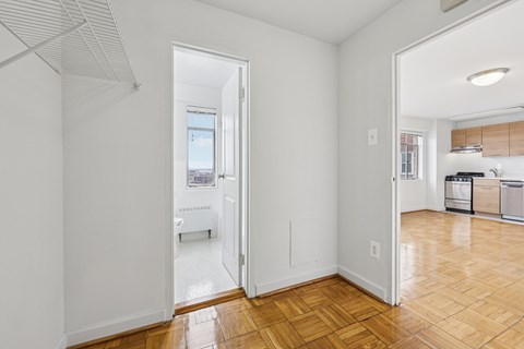 A kitchen with white cabinets and a wooden floor.