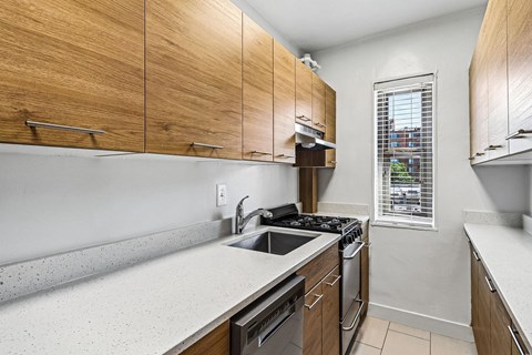 A kitchen with wooden cabinets and a window.