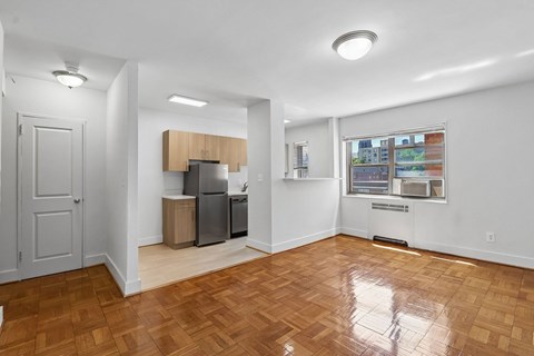 A kitchen area with a refrigerator, sink, and cabinets.