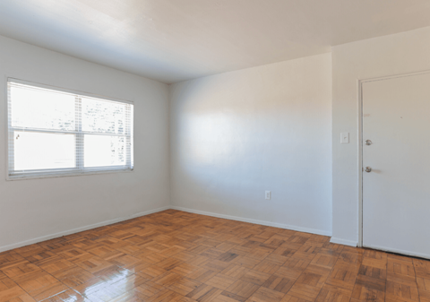 A room with a wooden floor and a window.