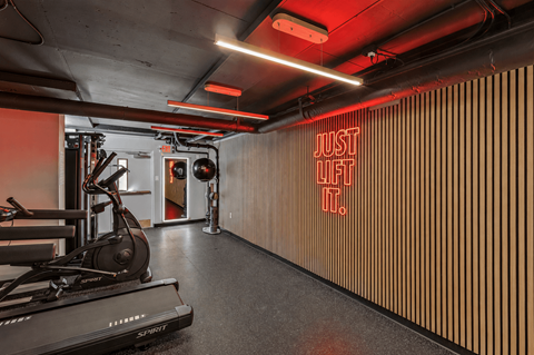 A gym with a rowing machine and a sign that says
