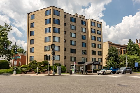 A large tan building with many windows is in the background.