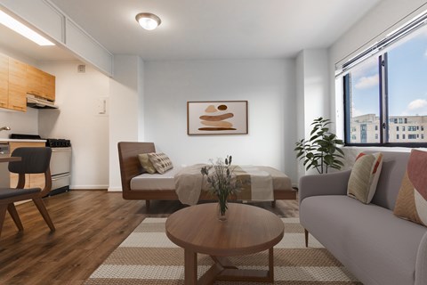 A modern living room with a grey sofa, wooden coffee table, and a large window.