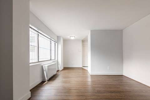 A long empty room with a window on the left side.