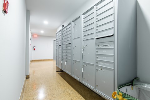 A long hallway with a row of mailboxes on the right.