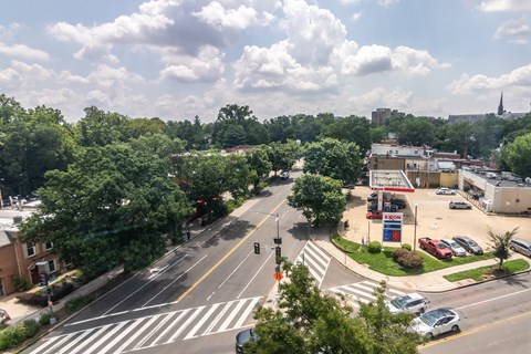 A city street with a gas station and trees.