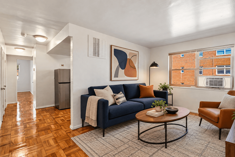 A living room with a blue couch and a wooden coffee table.