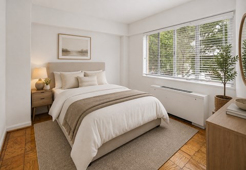 A bedroom with a large bed and a window with blinds.