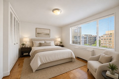A bedroom with two beds and a chair.