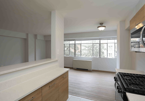 A kitchen with a black stove top oven and wooden cabinets.