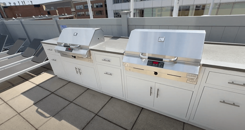 A white cabinet with a silver top is placed on a tiled floor.