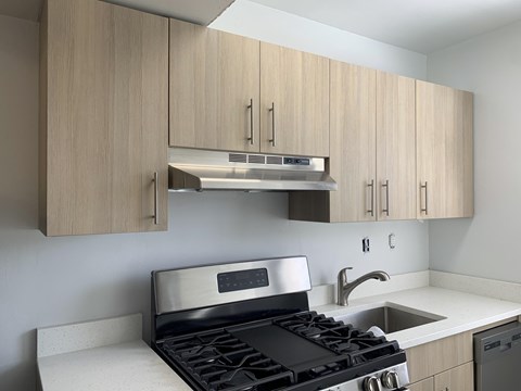 A modern kitchen with a stove top oven and a microwave above it.