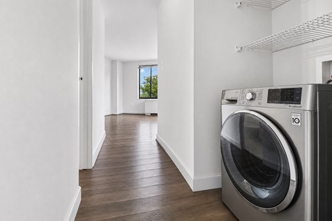 A modern laundry room with a washing machine on the right.