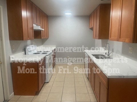 A kitchen with brown cabinets and a white countertop.