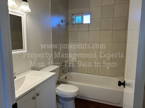 A white bathroom with a toilet, sink, and bathtub.