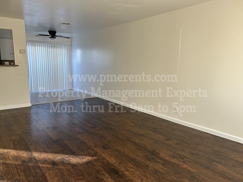A room with a wooden floor and a ceiling fan.