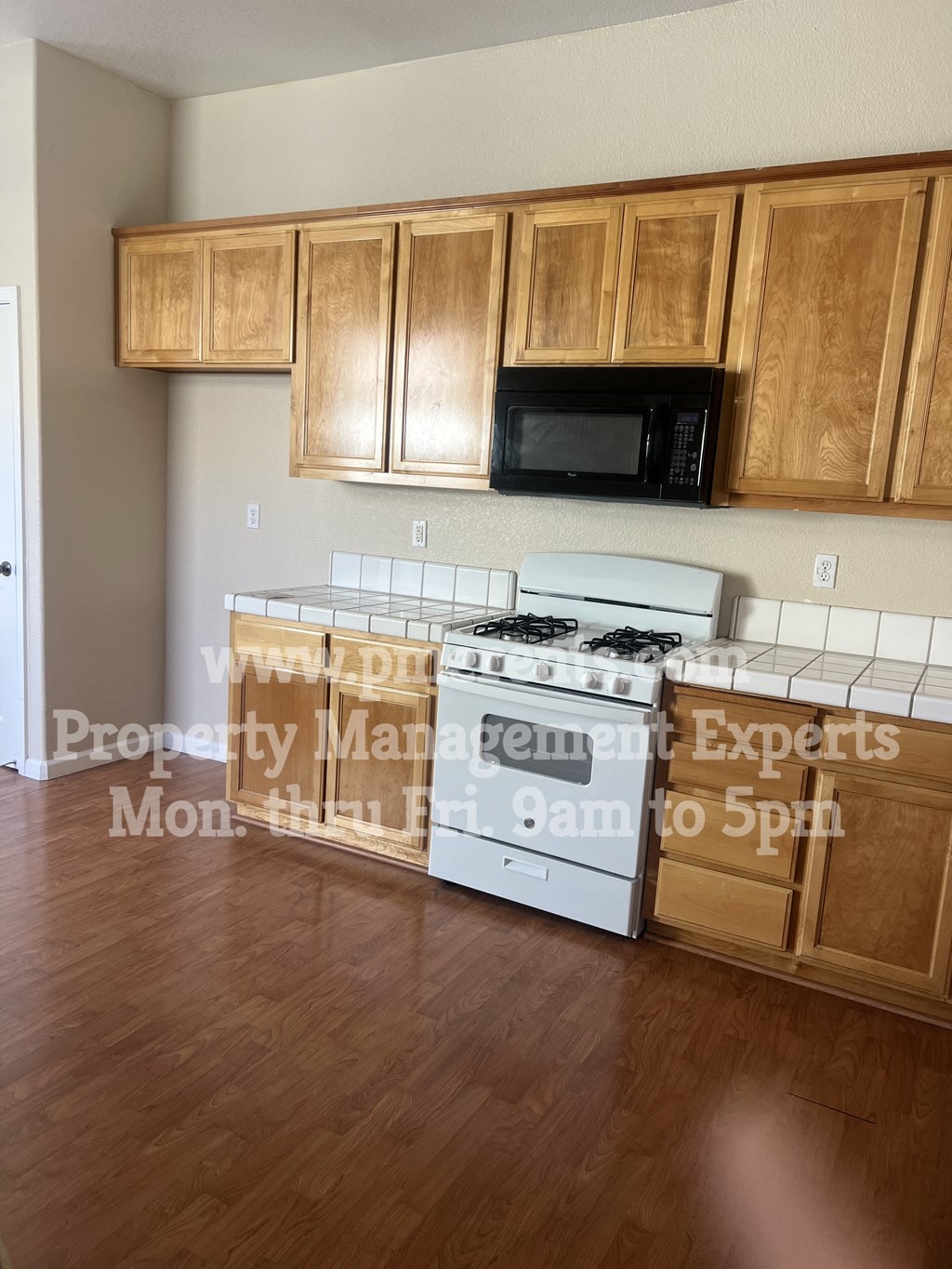 a kitchen with wooden cabinets and a stove and a microwave