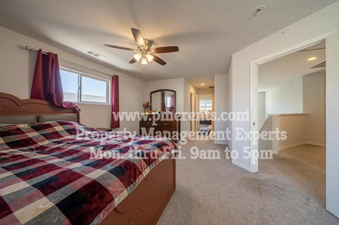 a bedroom with a bed and a ceiling fan