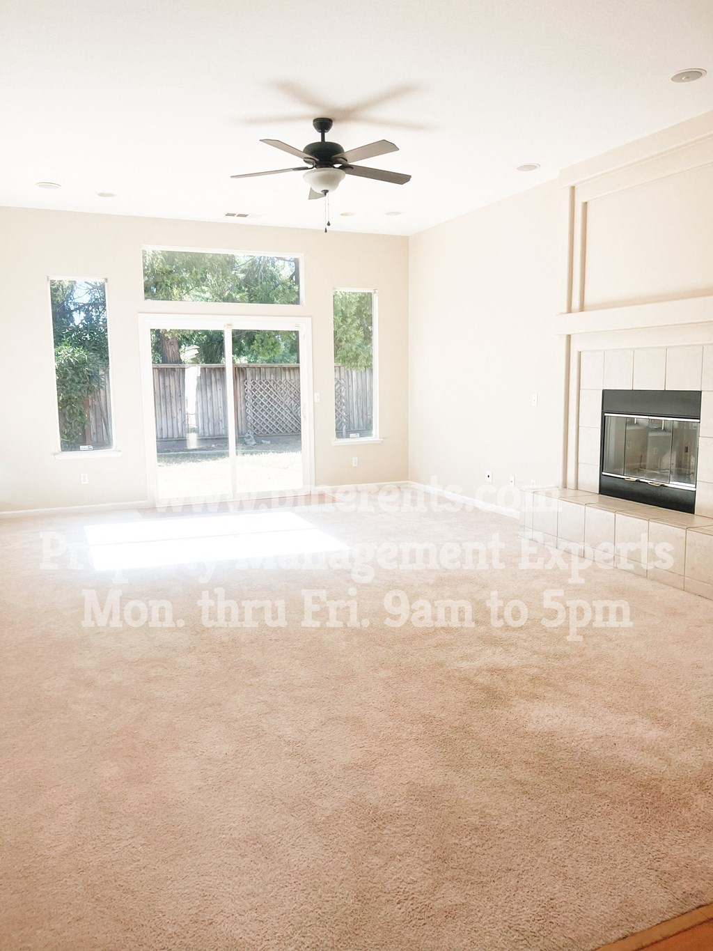 a living room with a ceiling fan and a fireplace