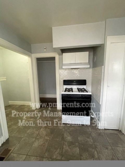 A kitchen with a stove top oven and a microwave above it.