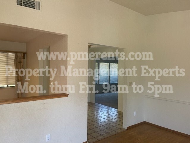 A room with a tiled floor and a window with blinds.