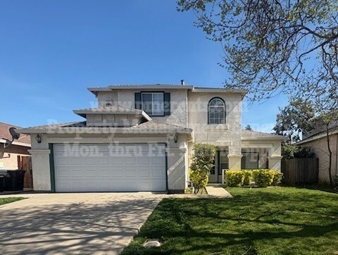 A two-story house with a garage and a driveway.