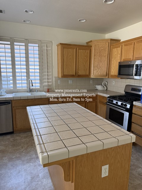A kitchen with wooden cabinets and a tiled island.