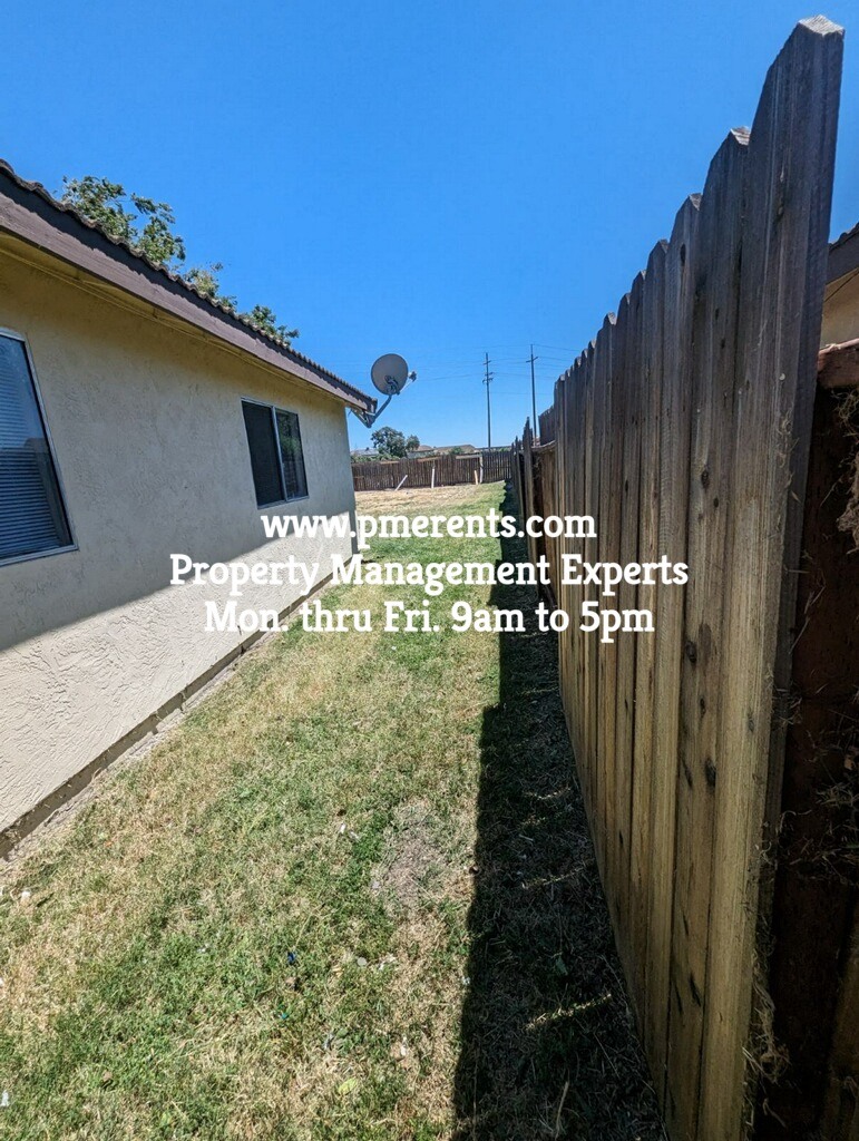 a backyard with a fence and a house