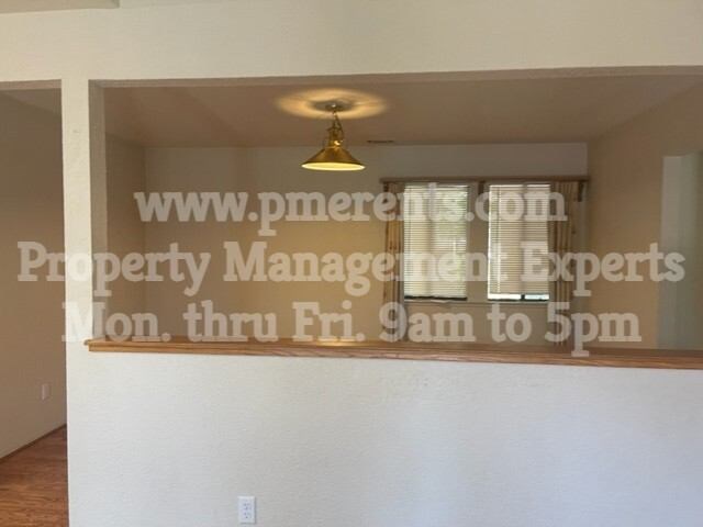 A sign in a window that says www.pmerens.com Property Management Experts Mon. thru Fri. 9am to 5pm.