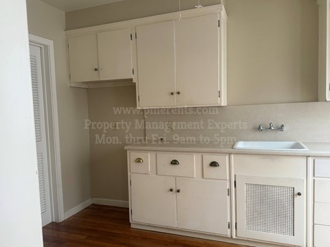 A kitchen with white cabinets and a sink.