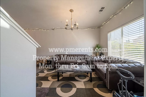 A living room with a checkered floor and a chandelier.