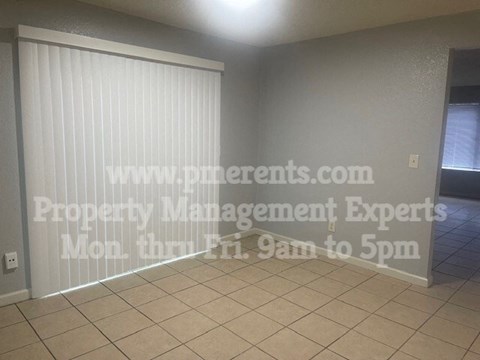 A room with a sign that says "www.pme.com Property Management Experts Mon thru Fri. 9am to 5pm".