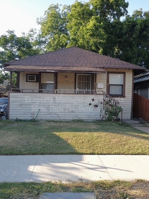 A small house with a brown roof and a white wall.