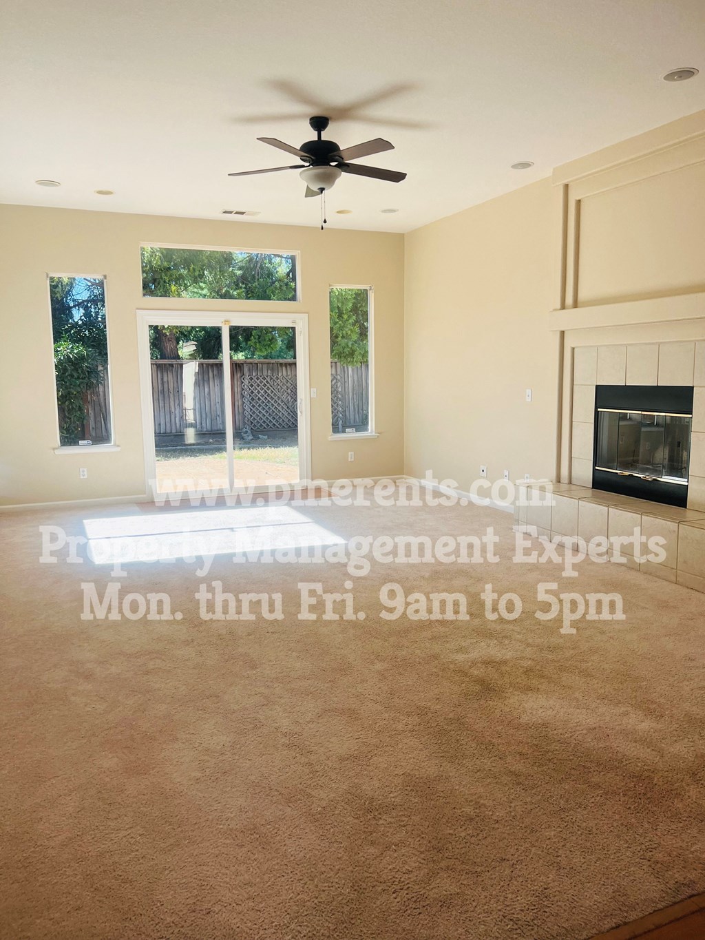 a living room with a fireplace and a ceiling fan