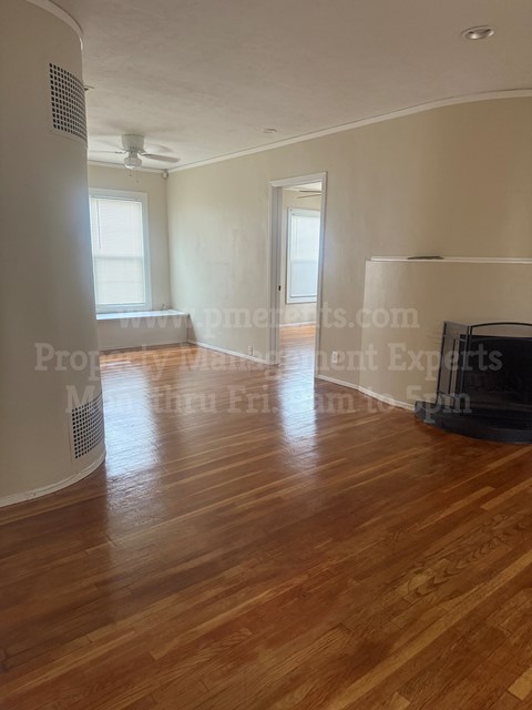 A room with wooden floors and a ceiling fan.