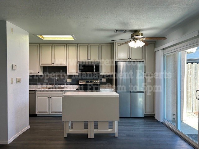 A kitchen with a table and chairs in front of a window.