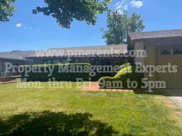 A sunny day with a house and a sign for www.pmrents.com Property Management Experts Mon through Fri 9am to 5pm.