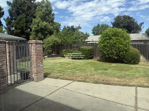 A backyard with a fence and a sign that says "No Parking to Be Signed".