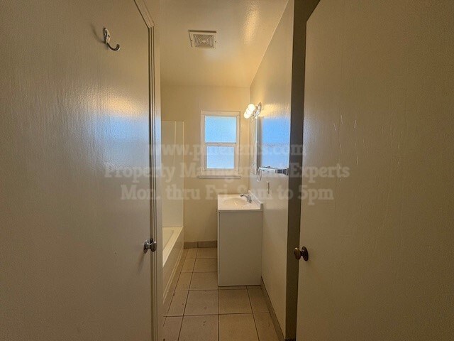 A small bathroom with a toilet, sink, and window.