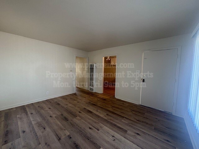 A room with wooden flooring and white walls.