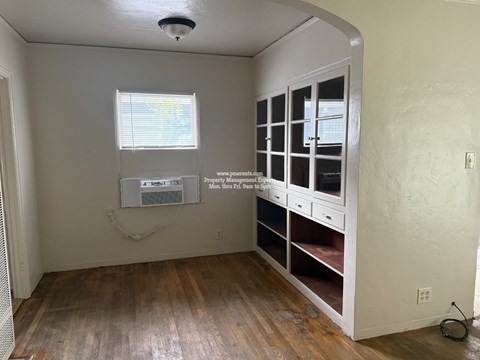A room with a window and a cabinet with drawers.