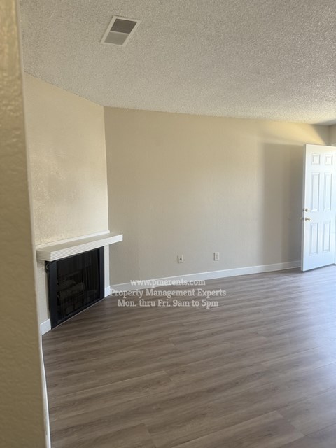A room with a fireplace and a door on the right side.