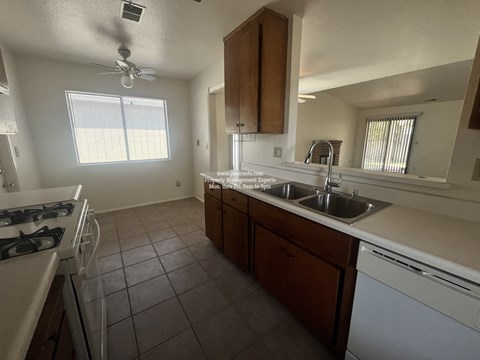 A kitchen with a white stove and a white dishwasher.