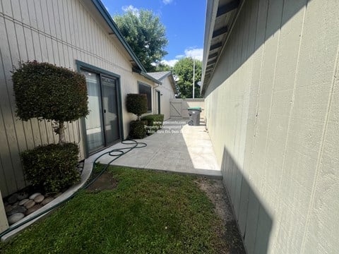 A sunny day at a residential area with a white building and a green lawn.