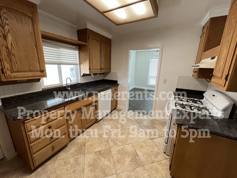 A kitchen with wooden cabinets and a black countertop.