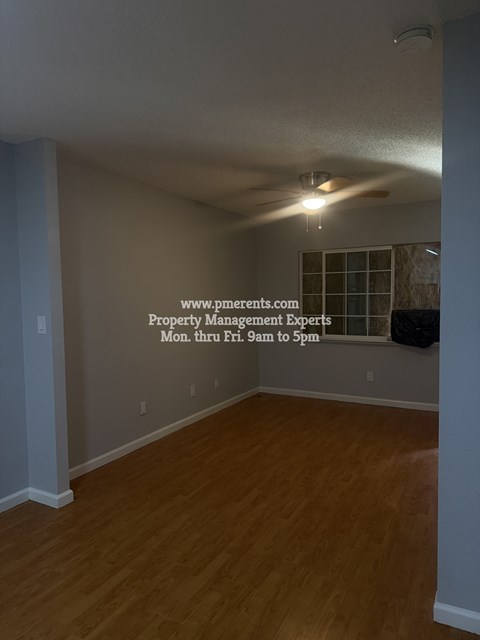 A room with a wooden floor and a ceiling fan.