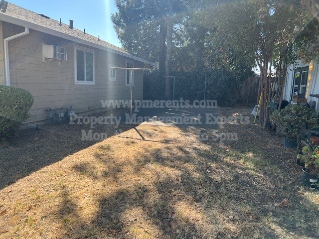 a back yard with a house and a tree